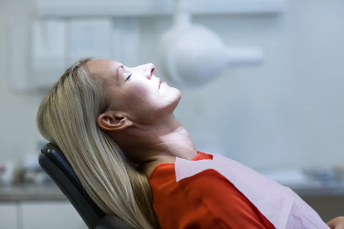 A woman receiving dental treatment with an oxygen mask at Zara Dental Houston for Sedation Dentistry