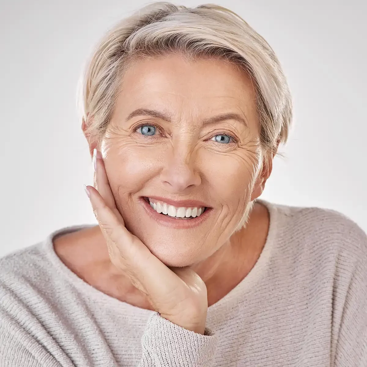 Woman with short hair smiling after All-on-4 dental implants
