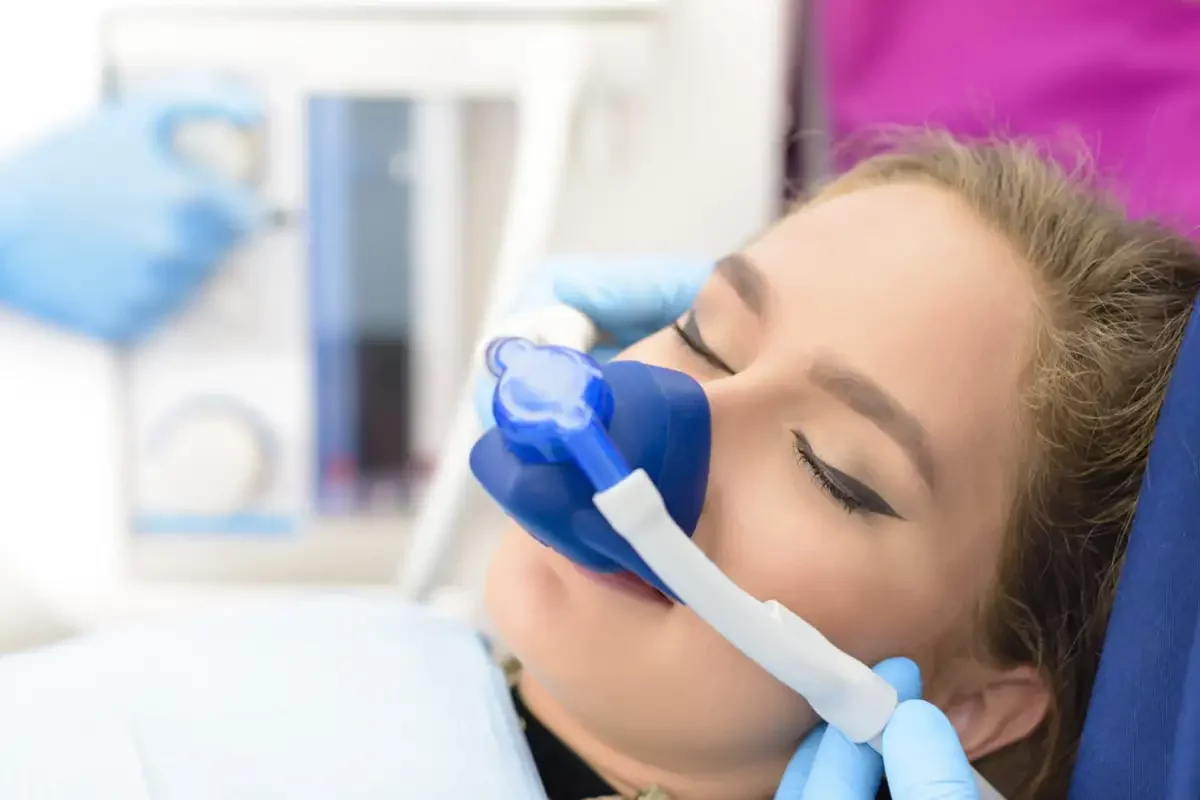 A woman receiving dental treatment with an oxygen mask at Zara Dental Houston for Sedation Dentistry