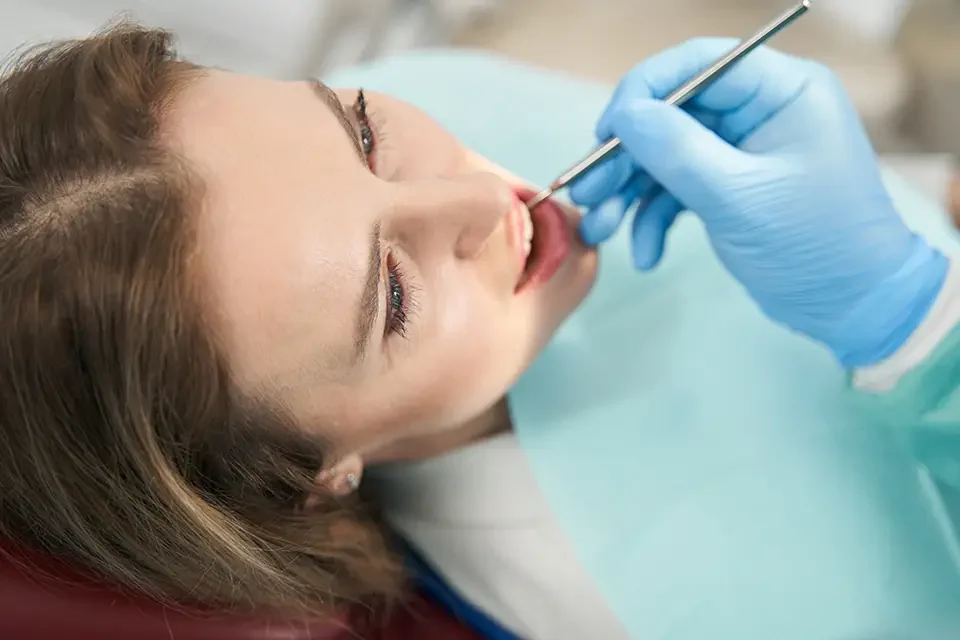 dentist-checking-woman-teeth-with-dental-mirror Oral Cyst Removal in Houston: What to Expect