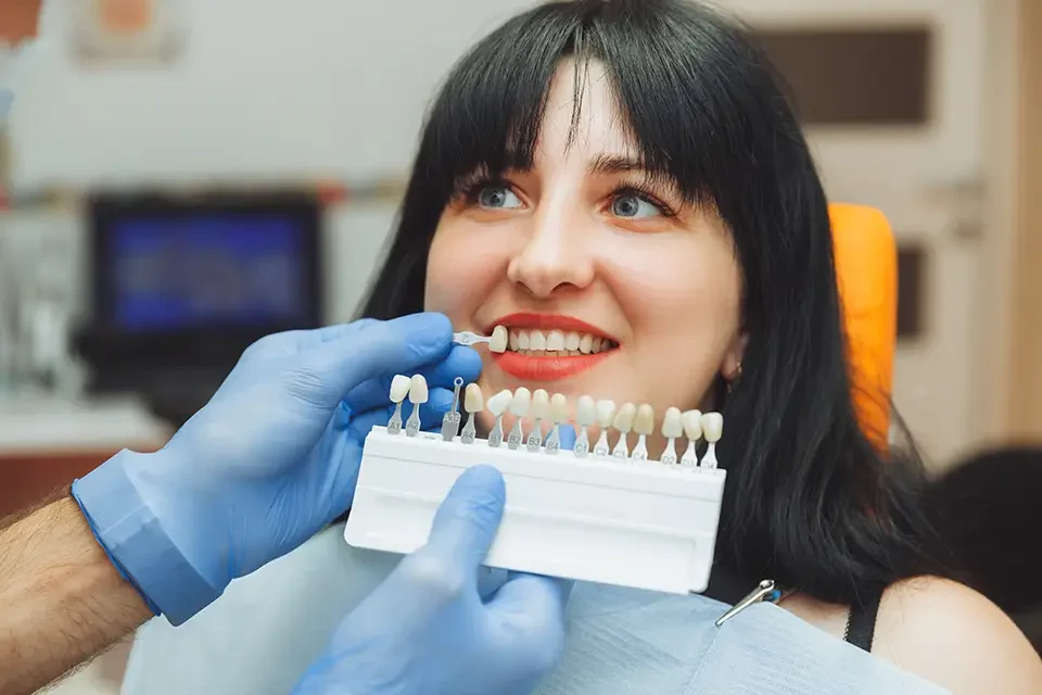 dentists selecting tooth color What Is a Dental Crown?