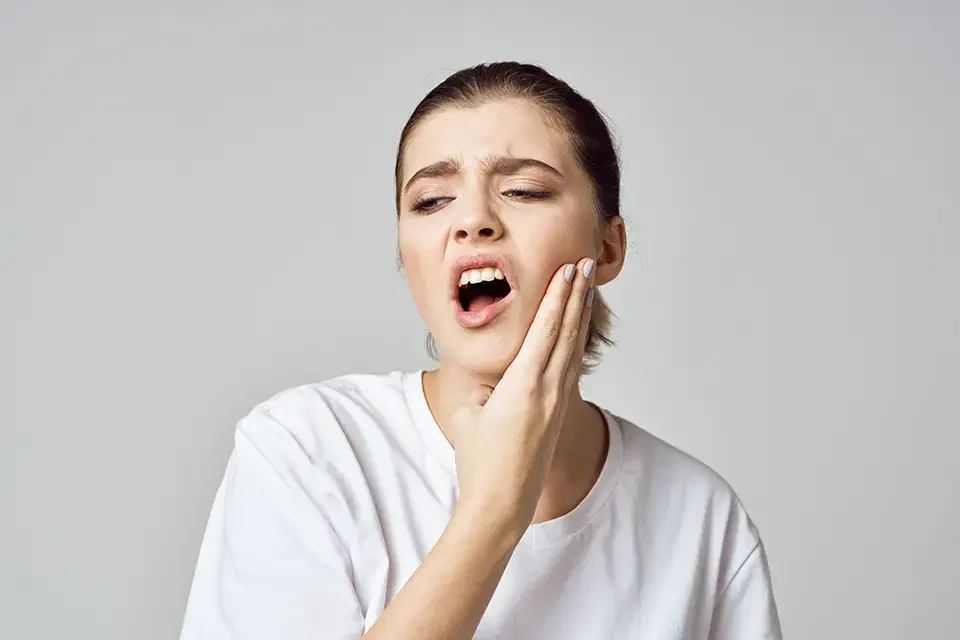 woman-holding-her-head-stress-emotions-discomfort When to Consider Wisdom Teeth Removal